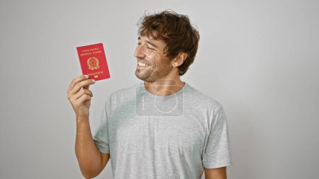 Young man smiling holding passport of italy over isolated white background
