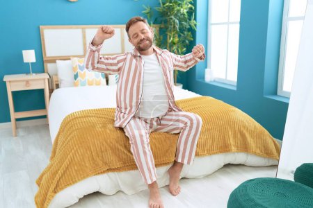 Photo for Middle age man waking up stretching arms at bedroom - Royalty Free Image