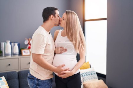 Téléchargez les photos : Homme et femme couple toucher ventre baisers à la maison - en image libre de droit