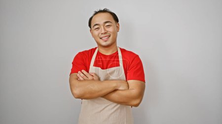 Téléchargez les photos : Jeune homme chinois confiant, serveur souriant avec les bras croisés, debout isolé sur fond blanc, dégage une ambiance de travail cool - en image libre de droit