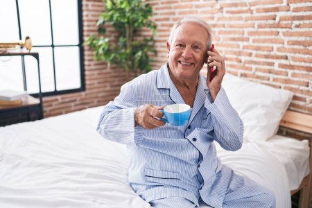 Photo for Middle age grey-haired man talking on smartphone drinking coffee at bedroom - Royalty Free Image