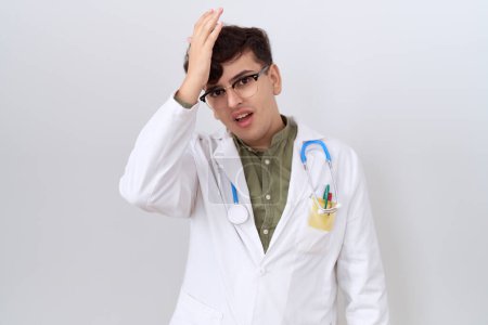 Photo for Young non binary man wearing doctor uniform and stethoscope surprised with hand on head for mistake, remember error. forgot, bad memory concept. - Royalty Free Image