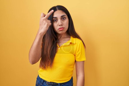 Photo for Young arab woman standing over yellow background showing middle finger, impolite and rude fuck off expression - Royalty Free Image