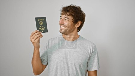 Jovial young man, with twinkling eyes, flaunts his taiwanese passport. standing solo against a white background, his smiling visage radiates confidence and pride.