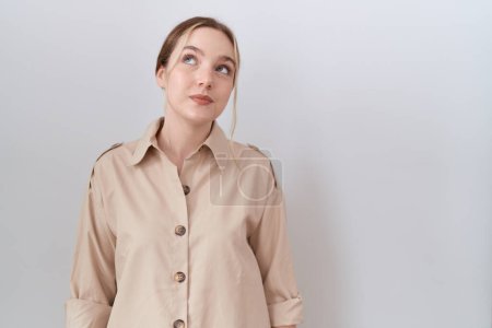 Foto de Joven mujer caucásica vistiendo camisa casual sonriendo mirando a un lado y mirando hacia otro pensando. - Imagen libre de derechos