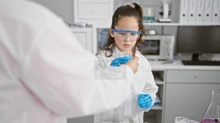 Téléchargez les photos : Deux scientifiques dévoués, travaillant intensément ensemble dans un laboratoire, en sécurité derrière leurs lunettes, immergés dans l'analyse des éprouvettes. - en image libre de droit