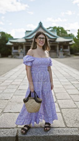 Photo for Cheerful latin beauty in glasses, a brunette woman poses with a confident and carefree smile at osaka's famous castle, overflowing with joy and happiness in japan's heritage tourism - Royalty Free Image