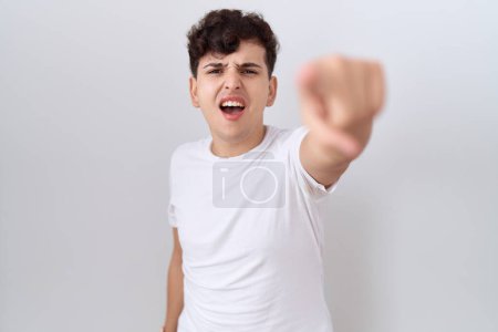 Téléchargez les photos : Jeune homme non binaire portant t-shirt blanc décontracté pointant mécontent et frustré à la caméra, en colère et furieux contre vous - en image libre de droit