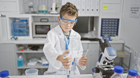 Foto de Científico chico rubio haciendo experimento en el laboratorio - Imagen libre de derechos