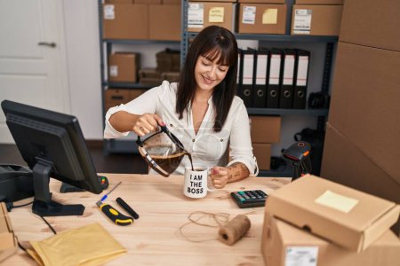 Jeune belle hispanique femme commerce électronique travailleur d'affaires verser du café sur la tasse au bureau