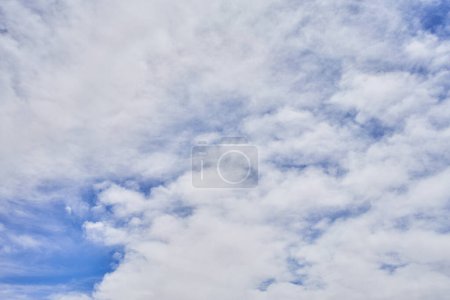 Foto de Nubes blancas esponjosas se dispersan a través de un cielo azul vibrante en una escena diurna natural serena y tranquila. - Imagen libre de derechos