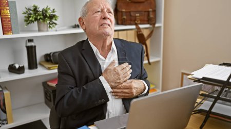 Photo for Elderly businessman endures agonizing heart attack at work, stress overwork takes toll on mature man in office - Royalty Free Image