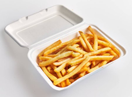 Photo for A styrofoam container filled with golden french fries isolated on a white background. - Royalty Free Image