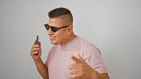 Young latin man dancing listening to music on smartphone over isolated white background
