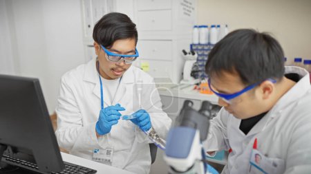 Foto de Dos hombres en un laboratorio trabajando juntos en un experimento científico con equipos de laboratorio. - Imagen libre de derechos