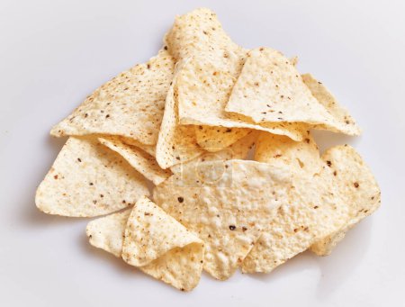 Foto de Una pila de chips de tortilla crujientes sobre un fondo blanco liso, adecuado para contenido relacionado con los alimentos. - Imagen libre de derechos