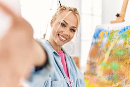 Téléchargez les photos : Young caucasian woman artist smiling confident make selfie by camera at art studio - en image libre de droit
