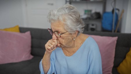 Elderly woman coughing indoors, showcasing health, senior lifestyle, and care within a domestic environment.