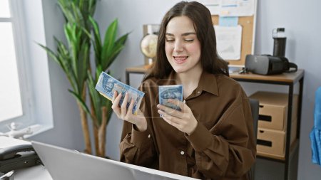 Foto de Una joven sonriente examina los billetes de forinto húngaros en un entorno de oficina moderno - Imagen libre de derechos