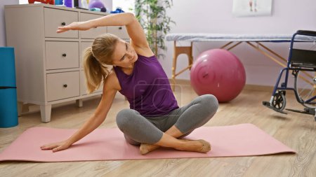 Mature woman exercising in a rehabilitation clinic's interior, showcasing healthcare and wellness.