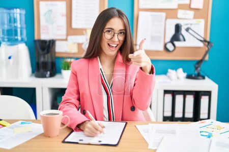 Photo for Young hispanic woman working at the office wearing glasses pointing fingers to camera with happy and funny face. good energy and vibes. - Royalty Free Image