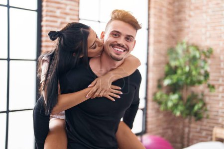 Téléchargez les photos : Homme et femme couple tenant petite amie sur le dos embrasser à la maison - en image libre de droit