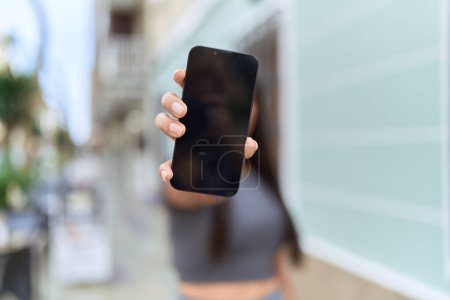 Photo for Young arab woman showing screen smartphone at street - Royalty Free Image