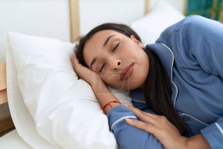 Young arab woman lying on bed sleeping at bedroom