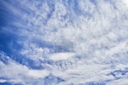 Eine ruhige Szene aus Zirrus- und Kumuluswolken breitet sich über den weiten blauen Himmel aus und stellt heiteres Wetter und natürliche Schönheit dar.