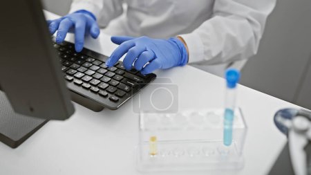 Foto de Mujer científica caucásica en laboratorio escribiendo en el teclado con la muestra de experimento y estetoscopio en interiores - Imagen libre de derechos