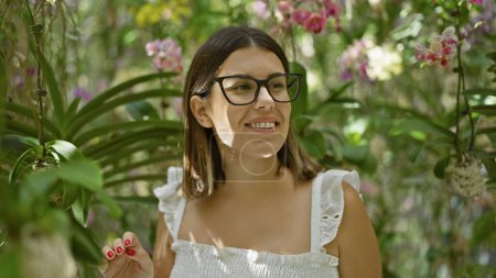 Happy hispanic woman in glasses, une exploration immersive de l'exposition de plantes futuristes dans un musée moderne et coloré