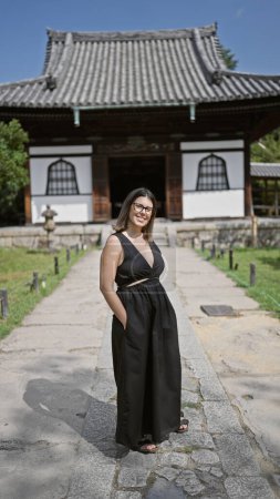 Joyeux belle femme hispanique, posant fièrement avec ses lunettes, clignotant un sourire magnifique au temple kodaiji serein de kyoto