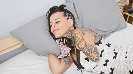 Femme hispanique avec bras amputé couché sur le lit dormant dans la chambre