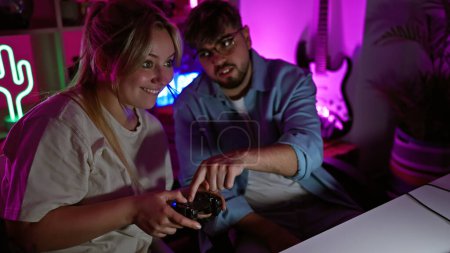 A woman and man enjoy a gaming session in a neon-lit room at night, symbolizing modern couple leisure time.