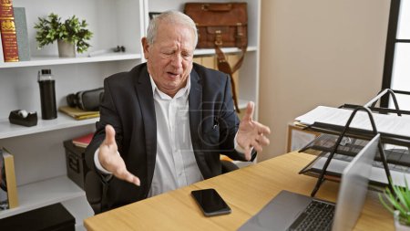 Photo for Angry senior man, a stressed business worker, furiously typing a message on his smartphone in the office - Royalty Free Image