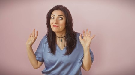 Téléchargez les photos : Une femme hispanique d'âge moyen avec une expression confuse debout sur un fond rose. - en image libre de droit