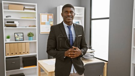 Photo for Confident african businessman standing in a modern office looking professional and handsome - Royalty Free Image