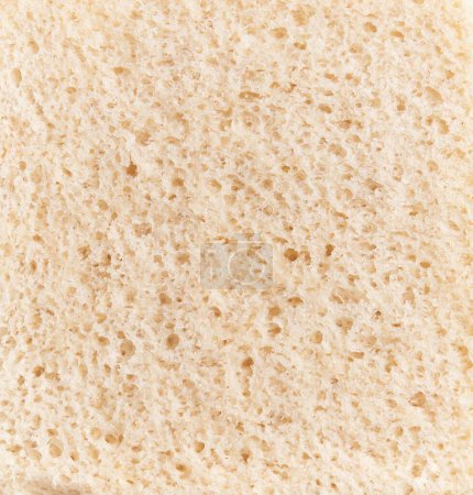 Foto de Textura de primer plano de un pedazo de pan blanco, haciendo hincapié en su superficie porosa y miga aireada para contextos culinarios. - Imagen libre de derechos