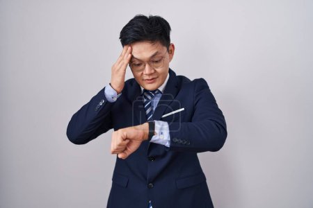 Foto de Joven asiático hombre vistiendo traje de negocios y corbata mirando el reloj tiempo preocupado, miedo de llegar tarde - Imagen libre de derechos