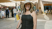 Smiling young woman with hat in a bustling dubai souq showcasing diverse market tourism. t-shirt #710162662