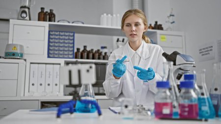 Photo for A young woman scientist works with chemicals in a laboratory, showcasing research and healthcare development. - Royalty Free Image