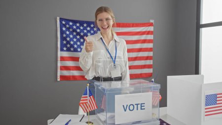Eine lächelnde junge kaukasische Frau reicht in einem US-Wahlzentrum mit amerikanischen Flaggen den Daumen nach oben.