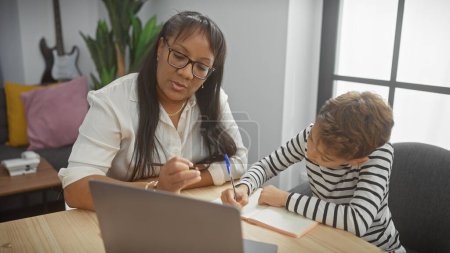 Photo for A woman helps a boy with homework in a cozy living room, symbolizing education and familial support. - Royalty Free Image