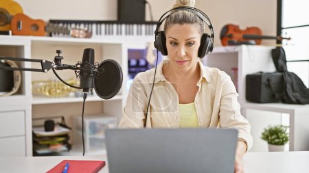 Téléchargez les photos : Jeune journaliste blonde parlant à la radio au studio de radio - en image libre de droit