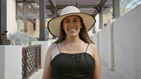 Foto de Una joven hispana adulta sonriente usando un sombrero de sol en el tradicional zoco madinat jumeirah, dubai. - Imagen libre de derechos