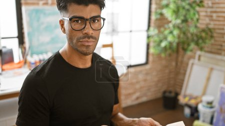 Photo for Handsome hispanic man with beard wearing glasses indoors at the academy - Royalty Free Image