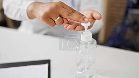 A person dispensing sanitizer indoors for hygiene in a potential healthcare environment