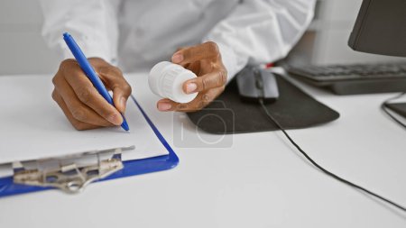 Téléchargez les photos : Afro-américaine femme pharmacien écriture prescription dans clinique bureau. - en image libre de droit