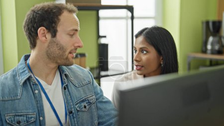 Téléchargez les photos : Deux travailleurs homme et femme utilisant l'ordinateur parlant au bureau - en image libre de droit