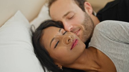 Foto de Hermosa pareja acostada en la cama abrazándose el uno al otro durmiendo en el dormitorio - Imagen libre de derechos